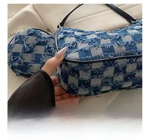 Dettaglio borsa a mezzaluna in denim a scacchi blu e bianchi con bordi sfrangiati e pelle