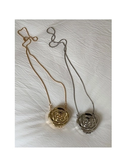 Macro detail of 3D rose flower locket pendants in gold and silver finish with snake chains
