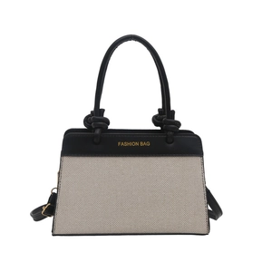 Two-tone woven square handbag with black leather handles and crossbody strap