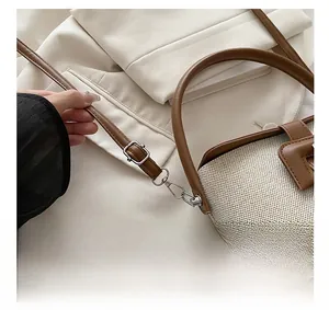 Détail de la boucle métallique ajustable et de la bandoulière en cuir du sac seau