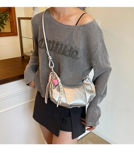 Silver crescent crossbody bag with pleated texture and cute heart charms on the side