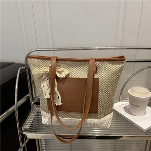 Large woven straw tote bag with brown leather pockets and decorative lace bow accents