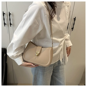 Dettaglio della borsa a spalla a mezzaluna color taupe con chiusura dorata lucida