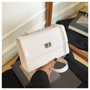 Détail du sac à main blanc à motif crocodile avec fermoir rotatif en métal argenté