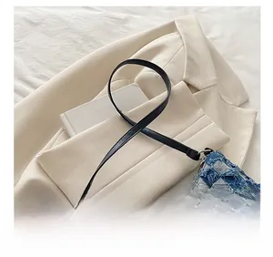 Dettaglio borsa a mezzaluna in denim blu a scacchi con bordi sfrangiati e tracolla