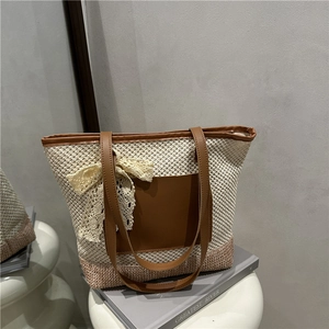 Handwoven straw tote bag with lace bow and leather handles for beach vacation