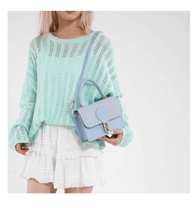 Détail du sac à bandoulière bleu clair avec fermoir rond et sangle réglable