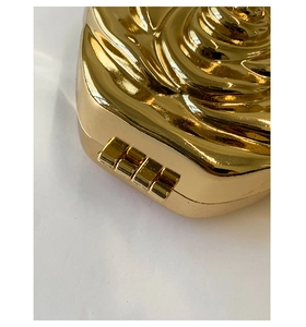 Detail view of golden rose evening clutch featuring metallic hinge and petal textures