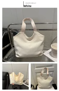Detail view of a white canvas tote bag with wide woven handles in minimalist style