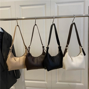 Minimalist PU leather crescent shoulder bags in multiple colors shown on a display rack