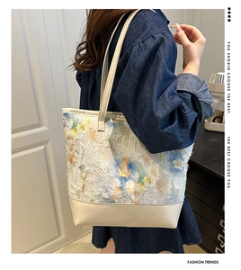 Dettaglio di ricamo floreale e pelle color crema su una borsa tote grande e alla moda