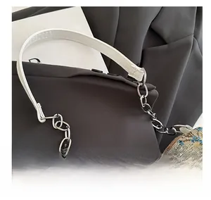 Detailed close-up of floral jacquard fabric and silver metal chain handle on stylish bag