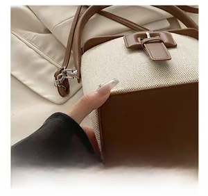 Coutures détaillées et texture d'un sac seau en toile beige et cuir marron