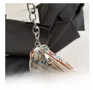 Close-up of smooth metal zipper and floral embroidery detail on vintage tote bag