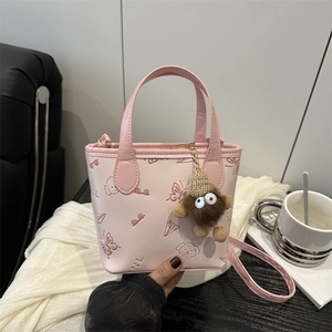 Pink bucket bag with cartoon embossed patterns, plush charm, and adjustable strap
