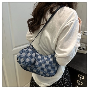 Dettaglio della borsa a mezzaluna in denim a scacchi bianchi e blu con bordi sfrangiati