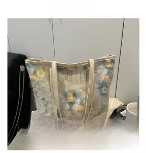 Dettaglio del ricamo floreale e del tessuto strutturato sulla borsa shopper