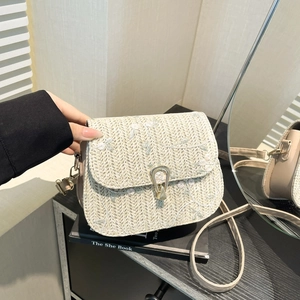 Beige straw saddle bag with delicate floral embroidery and gold metal clasp