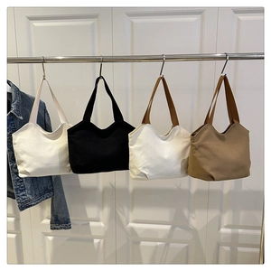 Detail of four canvas tote bags with wavy top edges and durable shoulder straps