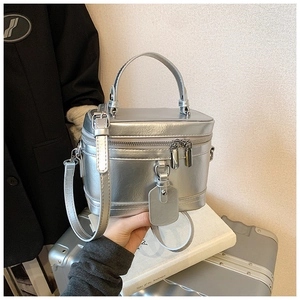 Detail of silver metallic structured handbag with top handle and secure zipper closure