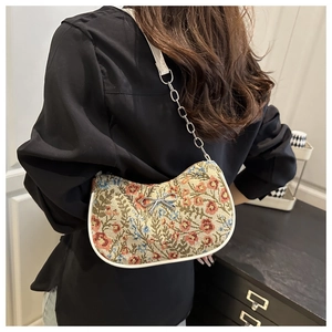 Detail view of floral hobo bag with silver bow accent and chain shoulder strap