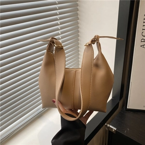Minimalist beige contrast shoulder bag with wide adjustable strap and gold metal hardware