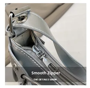 Detailed macro view of a smooth silver metal zipper on textured metallic leather bag