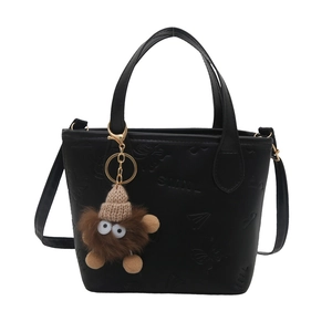 Contrast color embossed bucket bag with plush monster charm and adjustable shoulder strap