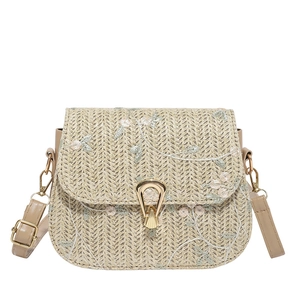 Beige woven straw crossbody bag with floral embroidery and gold clasp on white background