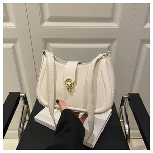 Dettaglio borsa a sella crema con fibbia ad anello in oro elegante e pelle sintetica