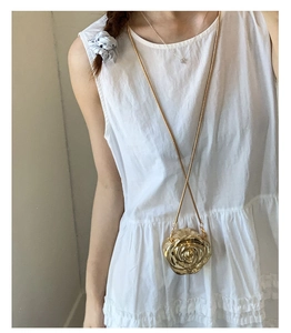 Detailed close-up of a mini gold rose-shaped acrylic clutch with delicate chain strap