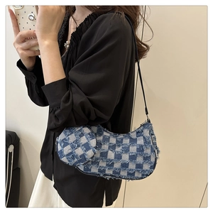 Dettaglio borsa a tracolla in denim a scacchi bianchi e blu con bordi sfrangiati e mini pochette