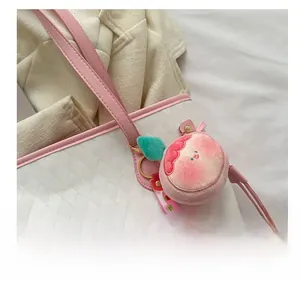 Close-up of a plush peach-shaped charm with green leaf on a white quilted tote bag