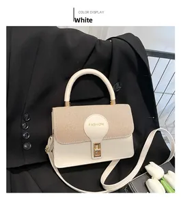 Detail of cream white handbag featuring woven texture flap and gold rectangular metal lock