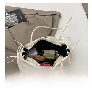 Vue de dessus de l'intérieur d'un sac en cuir crème montrant la capacité et la poche zippée