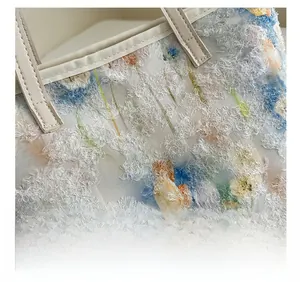 Dettaglio macro della borsa vintage con ricamo floreale 3D e tessuto testurizzato