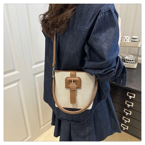Détail du sac seau en toile rétro avec garniture en cuir contrasté et boucle décorative