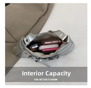 Internal capacity of silver metallic Y2K shoulder bag showing cosmetics and power bank