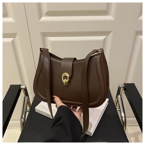 Dettaglio di borsa sottobraccio in pelle marrone scuro con chiusura dorata tonda