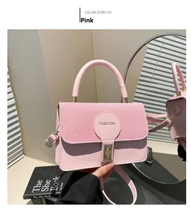 Detail of pink patchwork leather handbag featuring a golden clasp and fashion logo