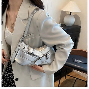 Silver Y2K punk style baguette bag with metal buckle details and adjustable shoulder strap