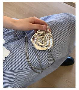 Detailed view of silver metallic rose-shaped clutch bag with elegant flower texture and chain