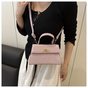 Detail of pink sequin trapezoid handbag with gold metal twist lock and slim shoulder strap