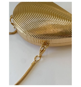 Detail of golden shell-textured evening bag with fine snake chain and lobster clasp