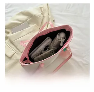 Detail view of large pink and white tote bag showing ample space for phone and umbrella