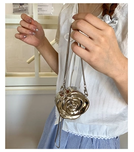 Detailed view of champagne gold rose evening bag with 3D petals and metal chain