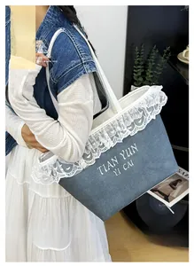 Detail of blue canvas tote bag featuring white lace edges and floral embroidery