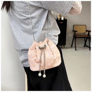 Detailed shot of pink lace embroidery bucket bag with chain strap and pearl charm