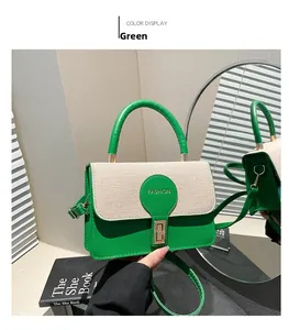Detail of green leather handbag with beige woven flap and gold fashion buckle closure