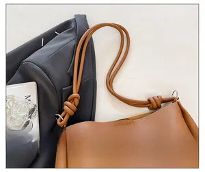 Vue macro de la bandoulière en cuir marron avec design noué et boucle métallique argentée